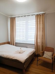 a bedroom with a bed and a window and a chair at Pokoje gościnne Jola in Drawsko Pomorskie