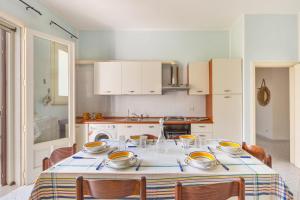 eine Küche mit einem Tisch mit Schalen und Tellern darauf in der Unterkunft Casa dei Marinai by BarbarHouse in Castro di Lecce