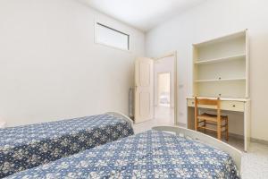 ein kleines Schlafzimmer mit 2 Betten und einem Schreibtisch in der Unterkunft Casa dei Marinai by BarbarHouse in Castro di Lecce