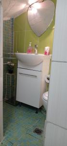 ein Badezimmer mit einem Waschbecken, einem WC und einem Spiegel in der Unterkunft Angel Room 1 in Nea Plagia