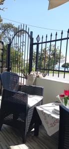a patio with two chairs and a table and a fence at Angel Room 1 in Nea Plagia +20 photos