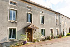 a large brick building with a wooden door at chambre indépendante dans le moulin in Pouilly-sur-Vingeanne