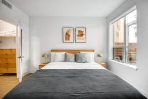 Un dormitorio blanco con una cama grande y dos ventanas. en Redwood City 1br w gym lounge wd nr Caltrain SFO-1232, en Redwood City