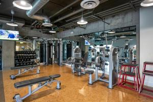 Un gimnasio con muchas máquinas de correr y una pared. en Redwood City 1br w gym lounge wd nr Caltrain SFO-1232, en Redwood City