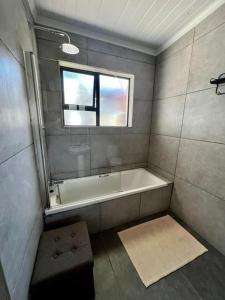 a bathroom with a bath tub and a window at 2 Bedroom Apartment in Waverley, Bloemfontein in Bloemfontein