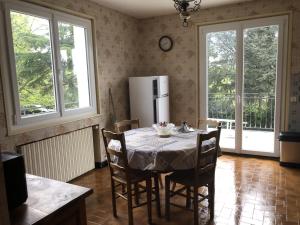 een keuken met een tafel met stoelen en een koelkast bij Chalet Echalas in Échalas