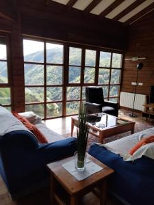 a living room with a blue couch and a table at CASA TABLADO HELENA in Belmonte de Miranda
