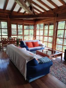 a bedroom with a bed and a couch and windows at CASA TABLADO HELENA in Belmonte de Miranda