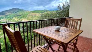 un tavolo in legno con una tazza di caffè sul balcone di Private Douro- Quinta das Susandas a Mesão Frio