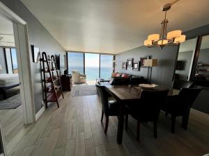 a dining room and living room with a table and chairs at Ocean View Luxury Condo Oceanfront and Pool in San Diego