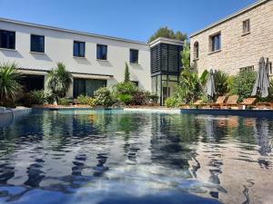 a swimming pool in front of a building at HPC Suites - Cassis Centre - Parking Gratuit & Piscine Chauffée in Cassis