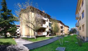 um prédio de apartamentos com uma árvore em frente em La casa di Bianca - Casa Vacanze em Villa Opicina