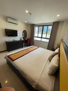 um quarto com uma cama grande e uma televisão em Tokia hotel nha trang em Nha Trang