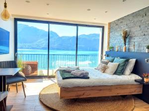 a bedroom with a bed with a large window at L'Edelweiss du Lac in Tresserves