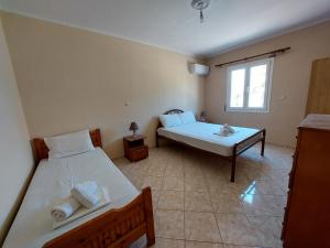 um quarto com 2 camas e uma janela em Lakkopetra Beach House em Kato Achaia