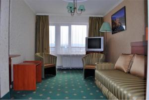 pokój hotelowy z kanapą i telewizorem w obiekcie Przystań Caryńska w Polańczyku w Polańczyku
