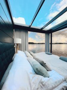 een groot bed in een kamer met een groot raam bij Lake Hotel Lehmonkärki - Haasi Mirror Houses in Asikkala