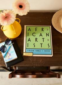 a table with a picture and a book and a vase at THE BIG - Luxury Backpackers in Cape Town