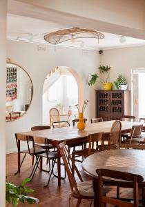 uma sala de jantar com mesas e cadeiras e um espelho em THE BIG - Luxury Backpackers em Cidade do Cabo