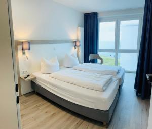 um quarto de hotel com duas camas e uma janela em Fewo Frida BOW 321 em Kappeln