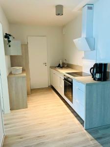 a kitchen with white appliances and a wooden floor at Fewo Frida BOW 321 in Kappeln