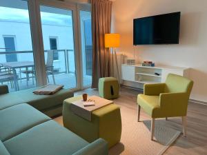 a living room with a couch and chairs and a television at Fewo Frida BOW 321 in Kappeln