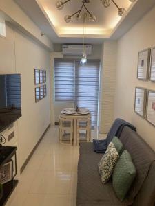 Coast Residence 4026 PENTHOUSE 1 Bedroom Condo with Wifi & Netflix في مانيلا: غرفة معيشة مع أريكة وطاولة