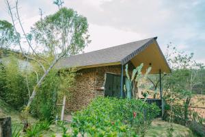 ceglany dom z czarnymi drzwiami w ogrodzie w obiekcie Shanti Wellness Sanctuary w mieście Ấp An Kroët