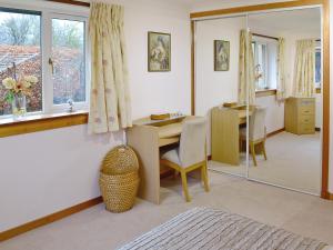 a living room with a table and a mirror at Eilean Donan in Kirknewton