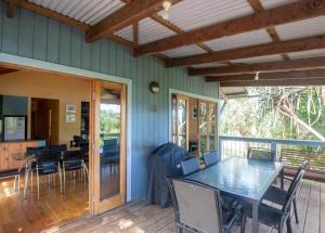 a dining room with a table and chairs on a porch at Bethongabel + Huge Home + sleeps 9 + Central in Point Lookout