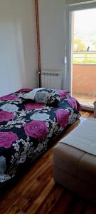a bedroom with a bed with a black and purple blanket at APARTMANI DIJANA in Trebinje