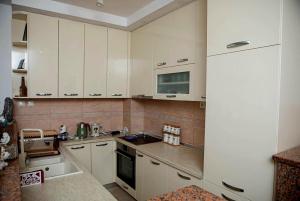 a kitchen with white cabinets and a sink at APARTMANI DIJANA in Trebinje