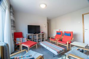 ein Wohnzimmer mit 4 Stühlen und einem TV in der Unterkunft Mondial 0201 in Middelkerke