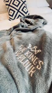 a blanket laying on top of a bed at The King's Parlour Whitehead in Whitehead