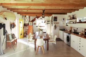 a kitchen with a wooden table and white chairs at The Boathouse in Velddrif