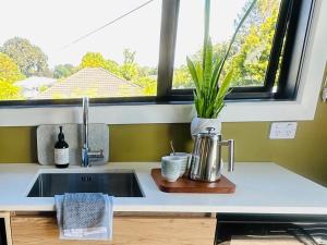 a kitchen counter with a sink and a window at Beckenham Studio on tree lined street in Christchurch