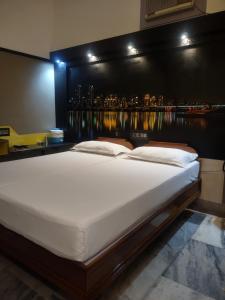 a large bed in a room with a view of a city at Krishna Lodge in Tiruchchirāppalli