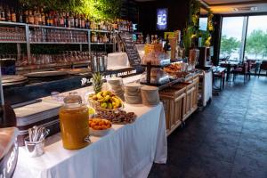 uma mesa com comida e bebidas num restaurante em Lodge Hôtel & Spa Les Voiles du Grand Large em Meyzieu