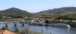 a bridge over a river with boats in a city at Casa Rural El Cubano in La Fregeneda