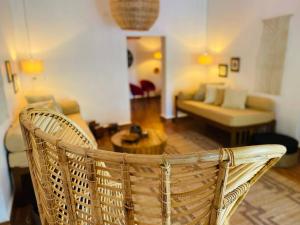 einen Korbstuhl in einem Wohnzimmer mit einem Sofa in der Unterkunft Villa Pont Bleu in Canacona