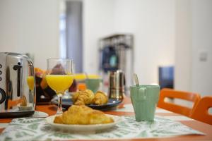 une table avec une assiette de nourriture et un verre de jus d'orange dans l'établissement Apartamento coqueto en la calle Huertas, à Madrid