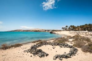 a beach with a heart shape in the sand at Home2Book Ocean Surf House Fuerteventura in La Oliva