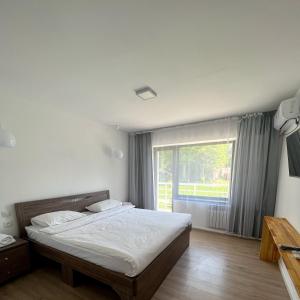 a bedroom with a bed and a large window at TOURIST HOTEL in Shymkent