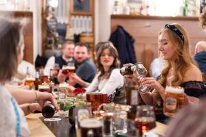 eine Gruppe von Menschen, die an einem Tisch mit Weingläsern sitzen in der Unterkunft Sperber Bräu - 3-Sterne-Superior Hotel mit Gasthof und eigener Brauerei - kein Ruhetag in Sulzbach-Rosenberg