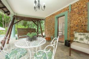 a patio with a table and chairs and a brick wall at Kruger Allo View B&B in Komatipoort