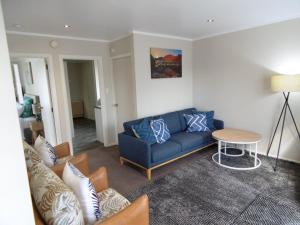ein Wohnzimmer mit einem blauen Sofa und einem Tisch in der Unterkunft Cambridge Bed & Breakfast in Cambridge