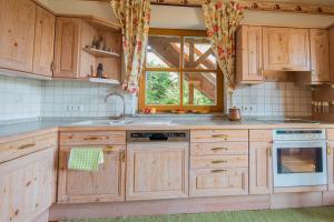 uma cozinha com armários de madeira e uma janela em Ferienwohnung Schwatlo em Mistelgau