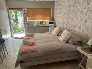 a large bed in a room with a kitchen at Cozy Corner Units in Langebaan