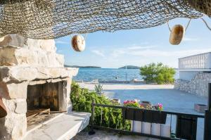 a view of the beach from a house with a stone fireplace at Blue of the sea in Krapanj