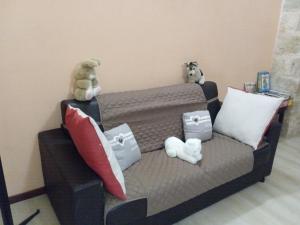 zwei ausgestopfte Tiere auf einer Couch mit Kissen in der Unterkunft The Nest of Envy in Bari